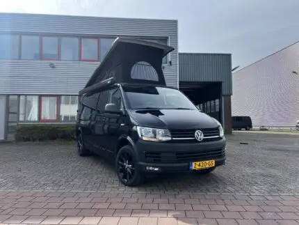 Geopend slaaphefdak met zwart doek op een Volkswagen buscamper – Meer hoofdruimte en ventilatie