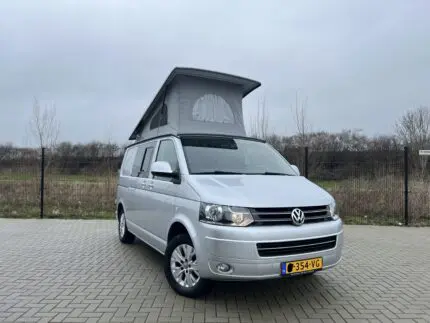 Geopend slaaphefdak met grijs doek op een Volkswagen buscamper – Meer hoofdruimte en ventilatie